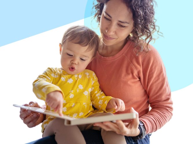 A parent and their toddler read a book together