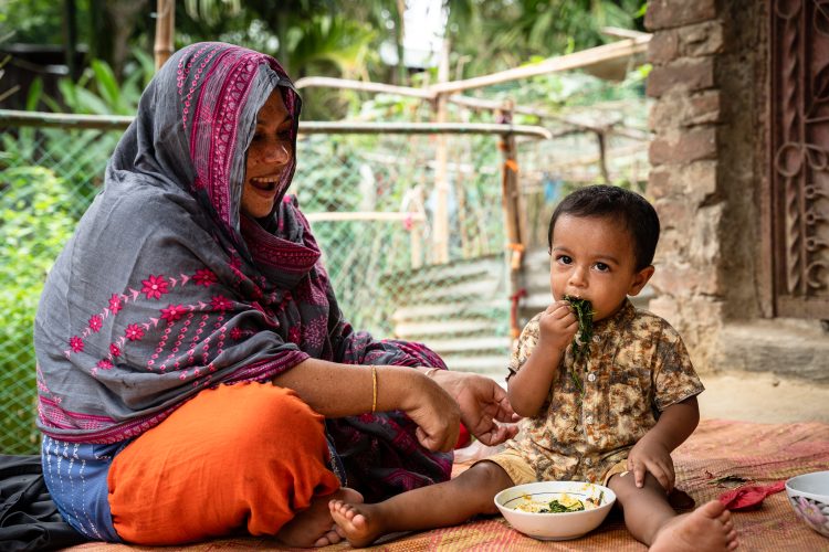 Child eating of his own makes mother happy and proud