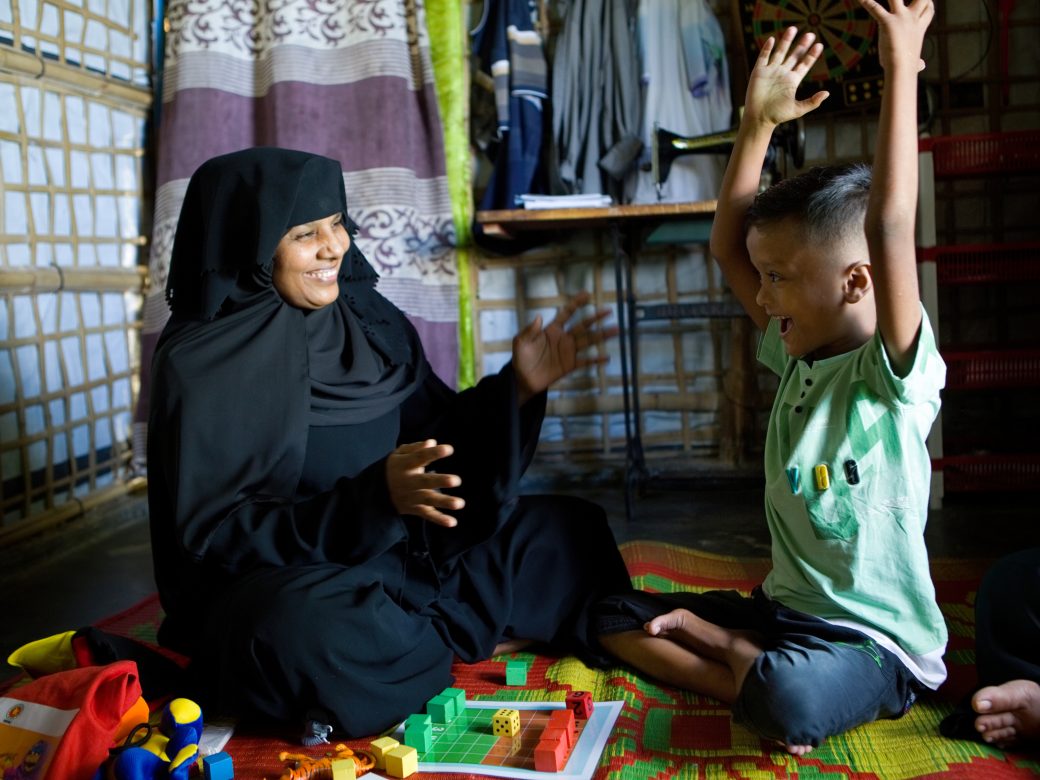 Woman playing blocks with a child.