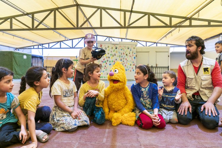 A group of children surround a happy Jad