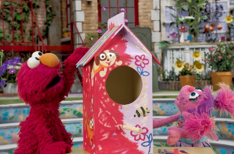 Elmo and Abby pose with a homemade birdhouse