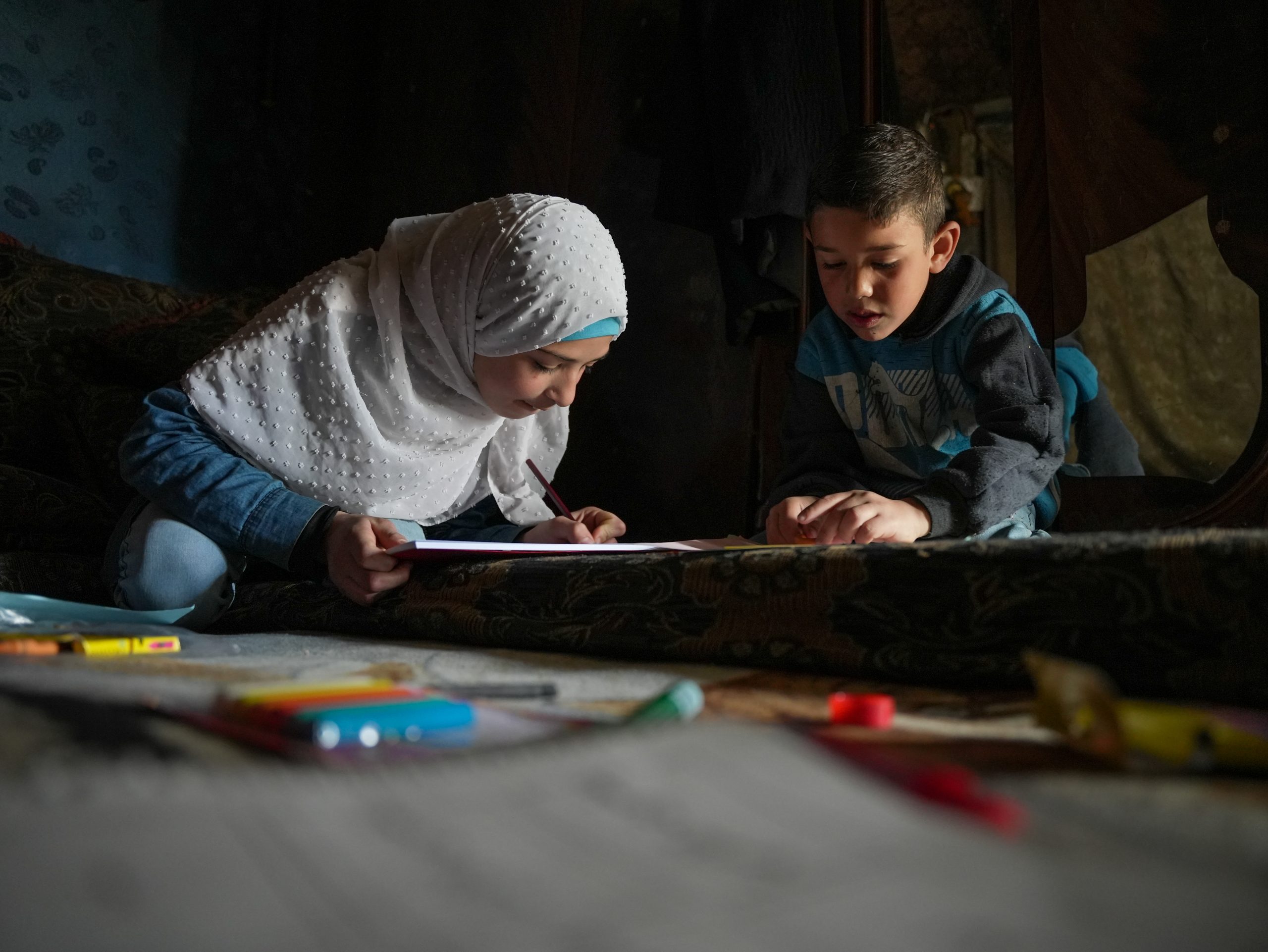 An adult and child complete schoolwork together