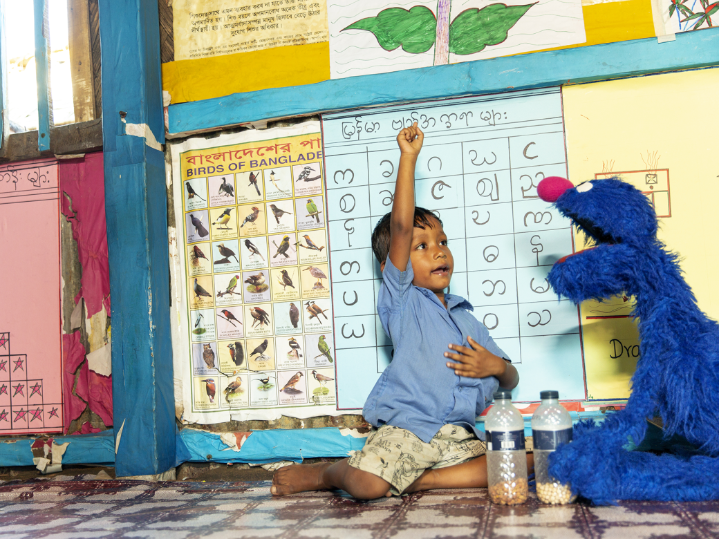 Grover playing with a child in a school.