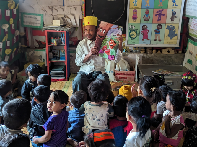 Adult reading to a group of children.