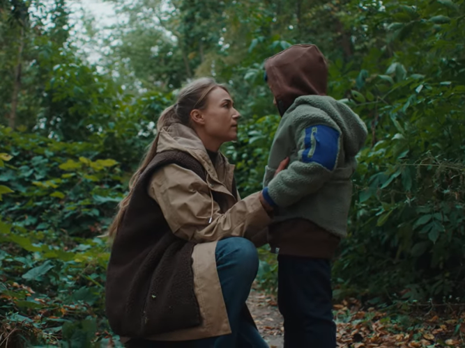 A parent comforts their child while hiking