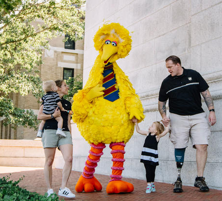 Big Bird walking with a military family