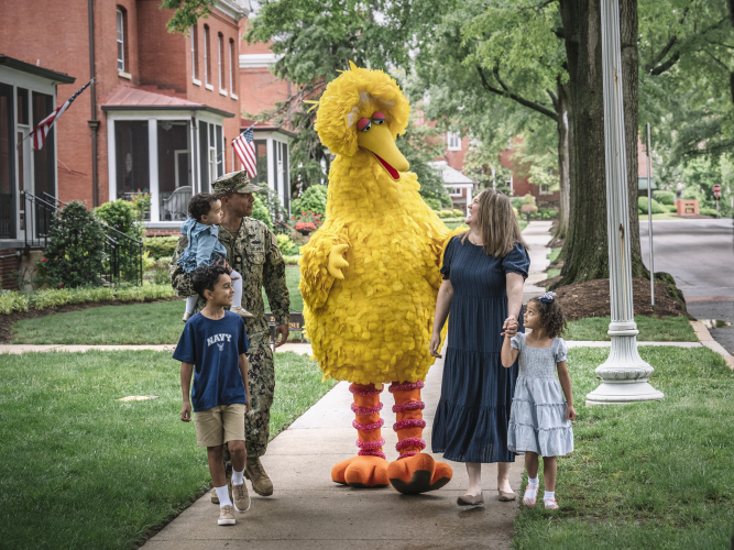 Big Bird walking with a military family.