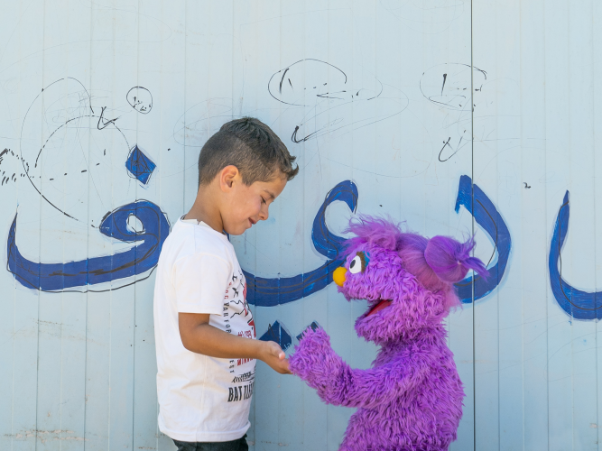 Basma holding hands with a child.