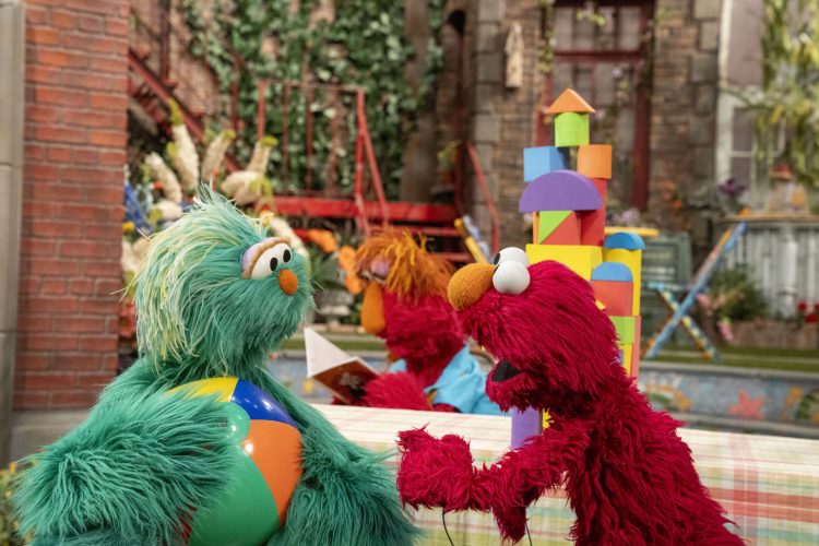 Elmo and Rosita playing with a ball.