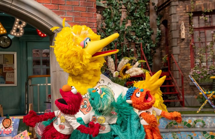 Big Bird, Elmo, Rosita and Rudy wearing camp sesame shirts.