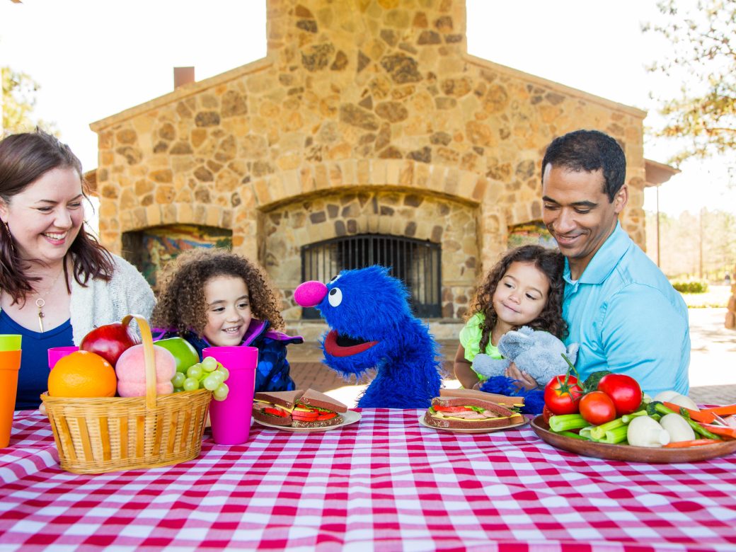 a family sitting at a picnic table.