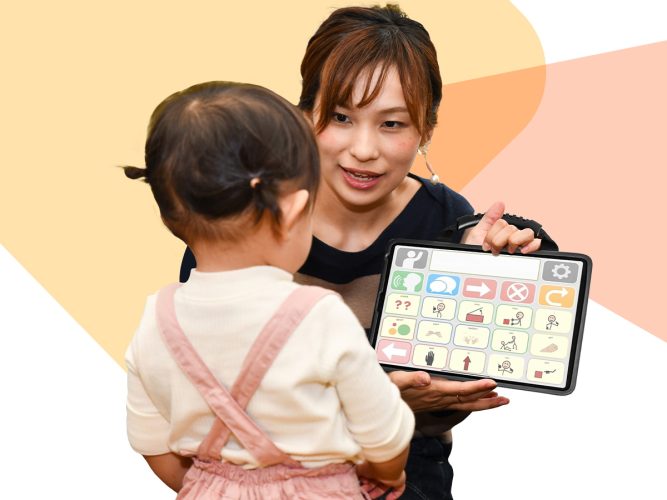 An adult and child looking at a talk pad.