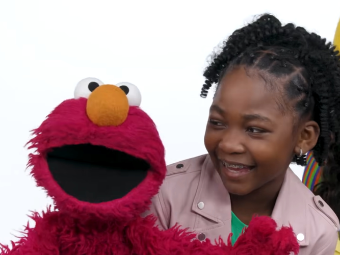 Elmo and child singing.