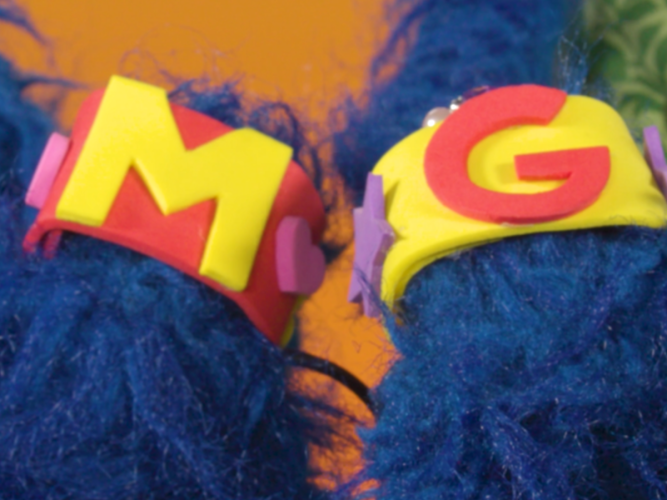 Grover and his mom showing their friendship bracelets.