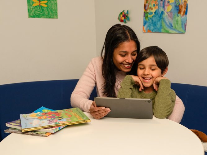 Parent and child looking at a tablet.