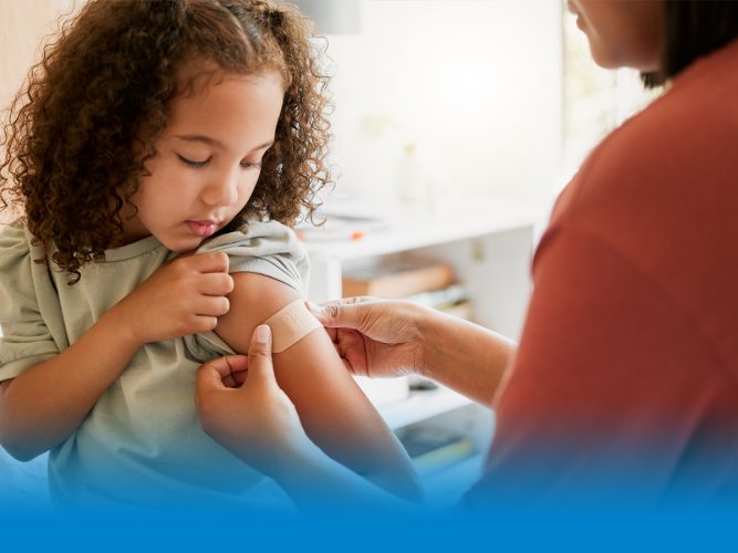 A child getting a band aid from a doctor.