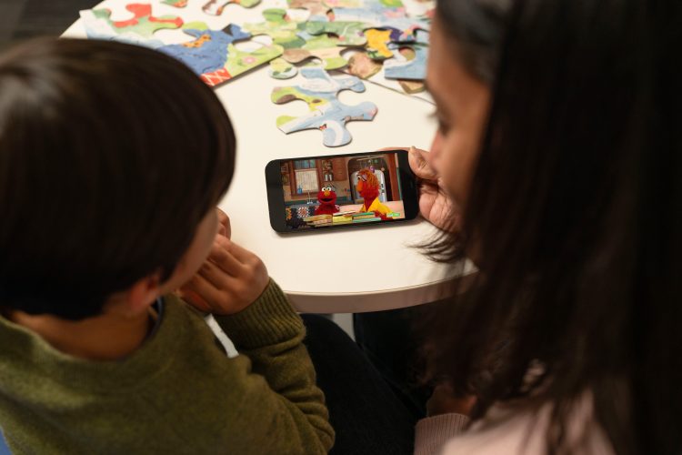 Parent and child looking at a video on a phone.