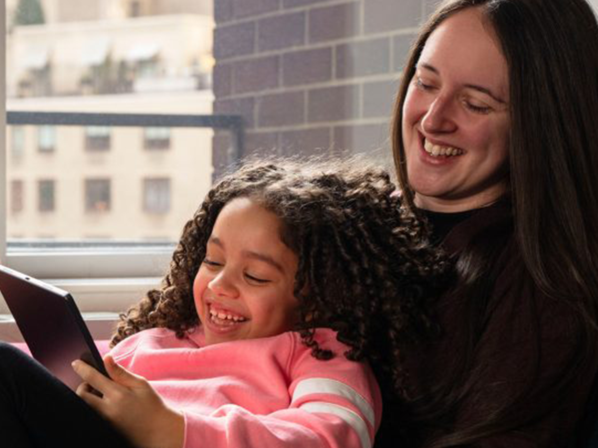 A parent and child on a tablet.