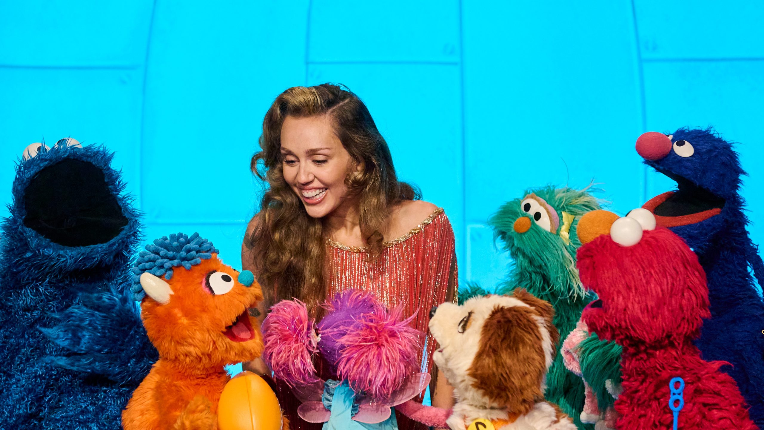 Miley Cyrus and Sesame Street Characters.