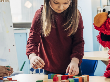 Elmo in a school with children.