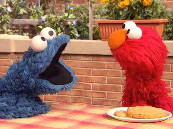 Cookie Monster and Elmo next to cookies.