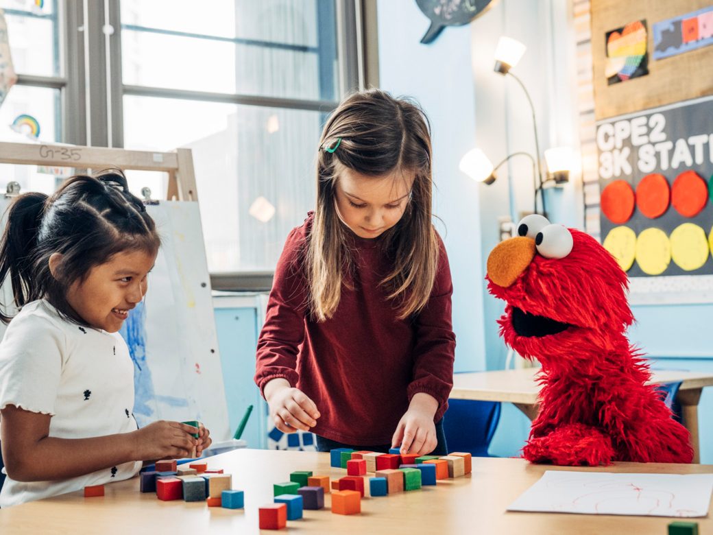 A child playing with Elmo.