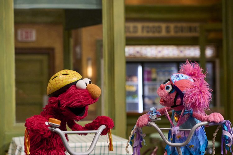 Abby and Elmo on bikes.