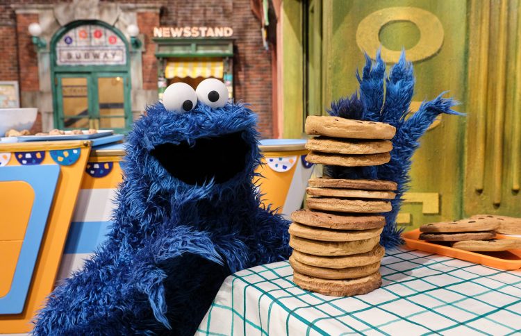 Cookie Monster with a stack of cookies.