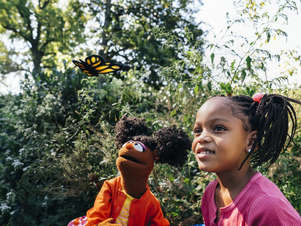 Gabrielle and a child looking at butterfly.