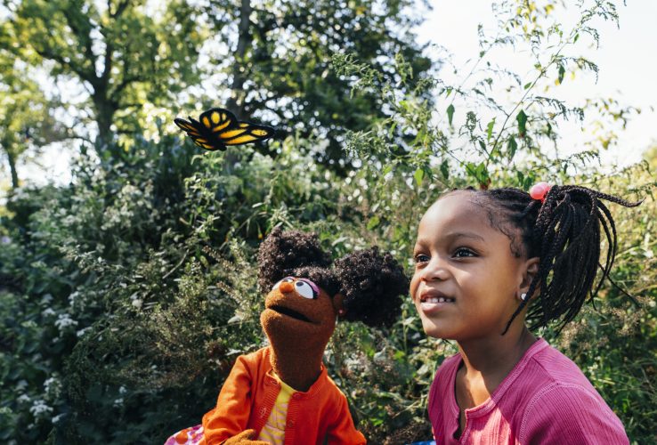 Gabrielle and a child looking at butterfly.